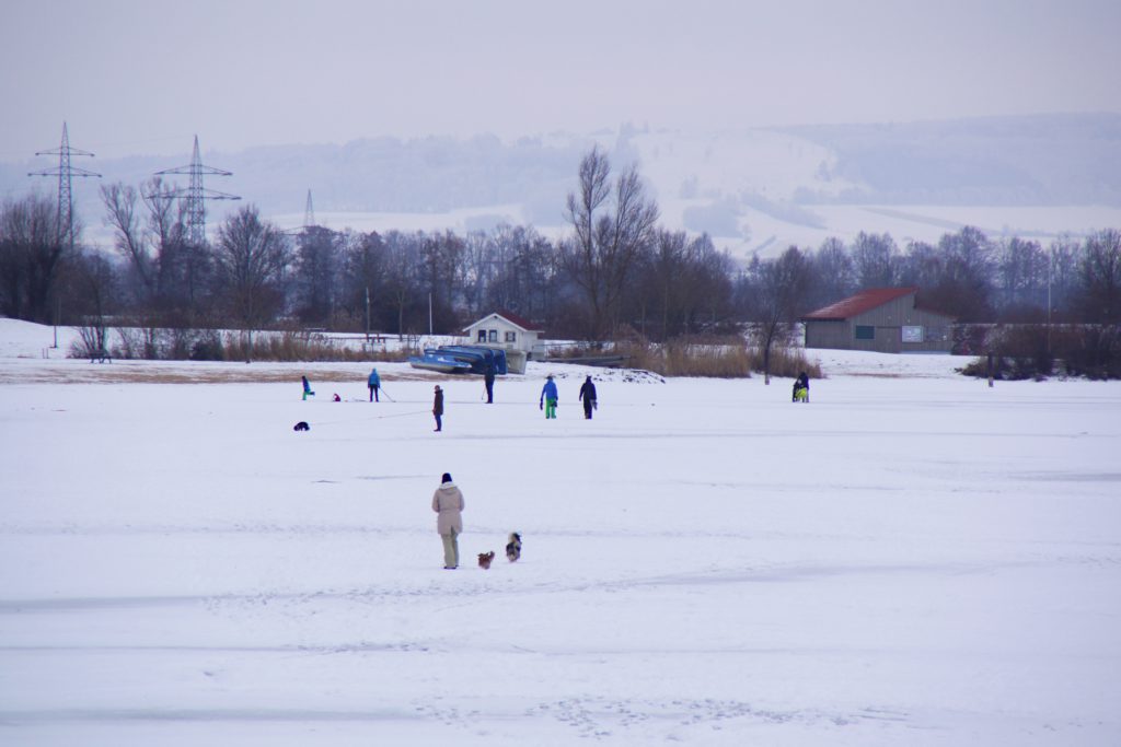Auf dem komplett gefrorenen Altmühlsee tummeln sich die Spaziergänger